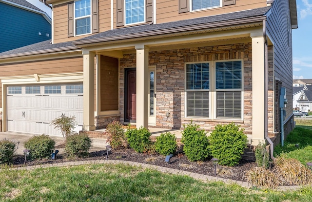 2003 Allerton Way, Spring Hill, TN 37174 - view of exterior entry featuring stone siding, covered porch, and a garage