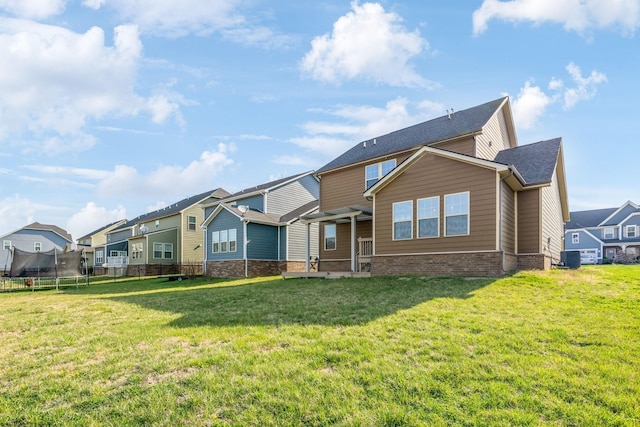 2003 Allerton Way, Spring Hill, TN 37174 - back of house with a trampoline, a residential view, a yard, and brick siding