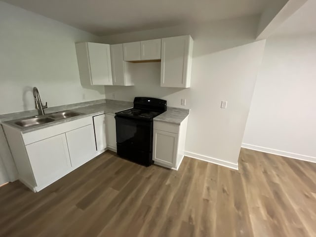 119 Maple Ave, Camden, TN 38320 - kitchen featuring black range with electric stovetop, a sink, dark wood finished floors, and white cabinets