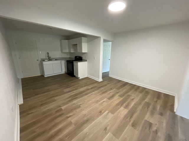 119 Maple Ave, Camden, TN 38320 - unfurnished living room featuring dark wood-style floors, baseboards, and a sink