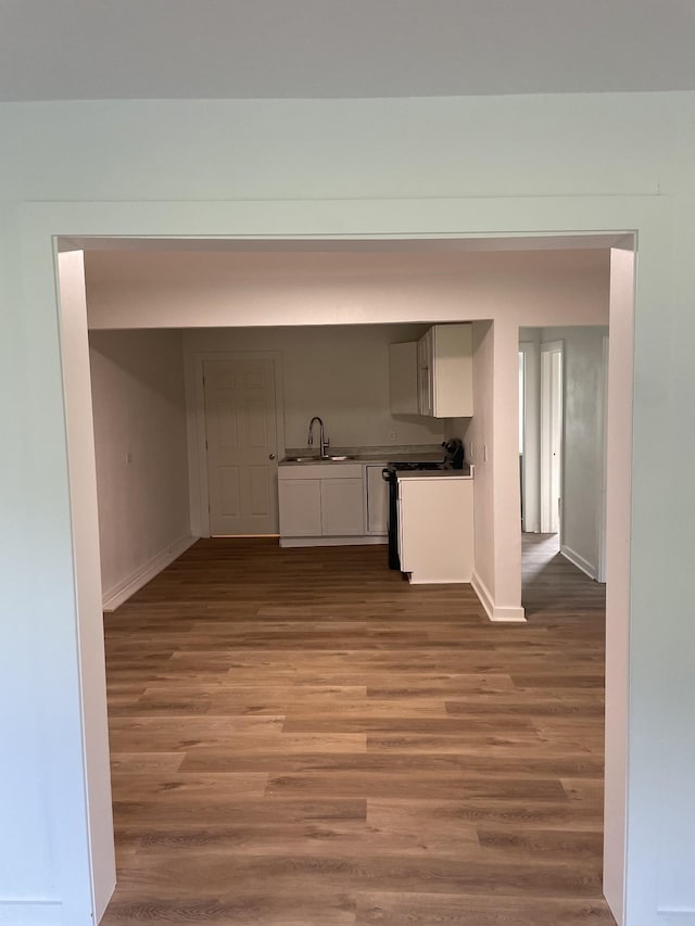 119 Maple Ave, Camden, TN 38320 - kitchen featuring baseboards, wood finished floors, a sink, and white cabinets