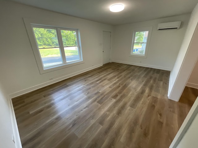119 Maple Ave, Camden, TN 38320 - unfurnished bedroom featuring an AC wall unit, wood finished floors, and baseboards