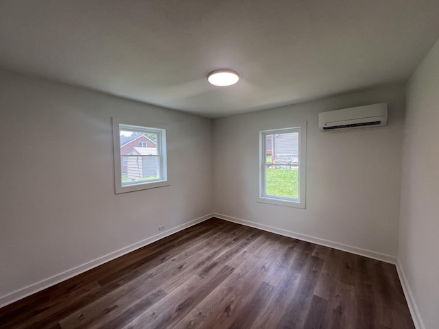 119 Maple Ave, Camden, TN 38320 - unfurnished room featuring a wall mounted AC, plenty of natural light, and dark wood-style flooring