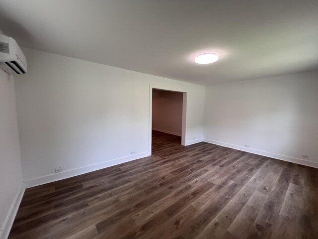 119 Maple Ave, Camden, TN 38320 - empty room featuring dark wood-style flooring and a wall mounted AC