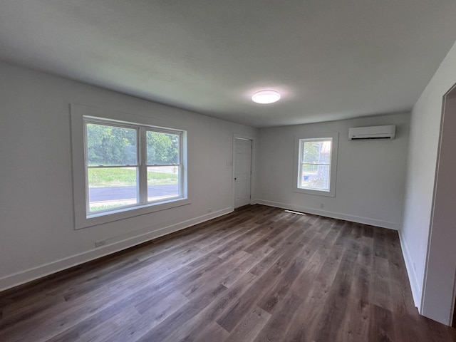 119 Maple Ave, Camden, TN 38320 - spare room with a wall unit AC and dark wood-style floors