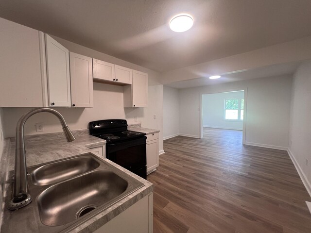 119 Maple Ave, Camden, TN 38320 - kitchen with black range with electric cooktop, white cabinetry, dark wood-type flooring, and light countertops