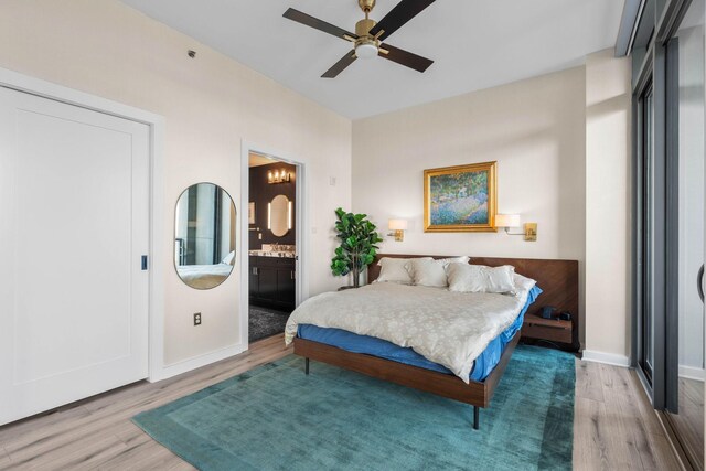 900 20th Ave S Unit 1601, Nashville, TN 37212 - bedroom featuring wood finished floors, baseboards, ensuite bath, and ceiling fan