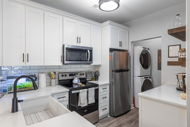 7234 Althorp Way Unit U8, Nashville, TN 37211 - kitchen with appliances with stainless steel finishes, stacked washing machine and dryer, a sink, backsplash, and wood finished floors