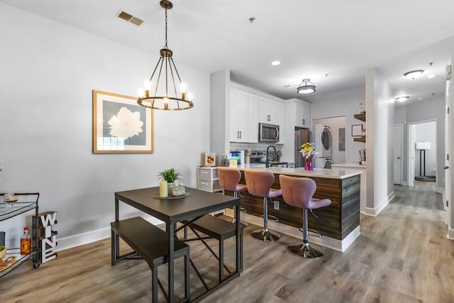 7234 Althorp Way Unit U8, Nashville, TN 37211 - dining area with stacked washer / dryer, light wood-style flooring, baseboards, and recessed lighting