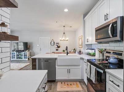 7234 Althorp Way Unit U8, Nashville, TN 37211 - kitchen with stainless steel appliances, a sink, a peninsula, light countertops, and recessed lighting