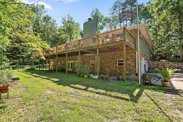204 Chapman Ct, La Fayette, GA 30728 - rear view of house with a lawn, a wooden deck, an attached garage, stone siding, and a chimney
