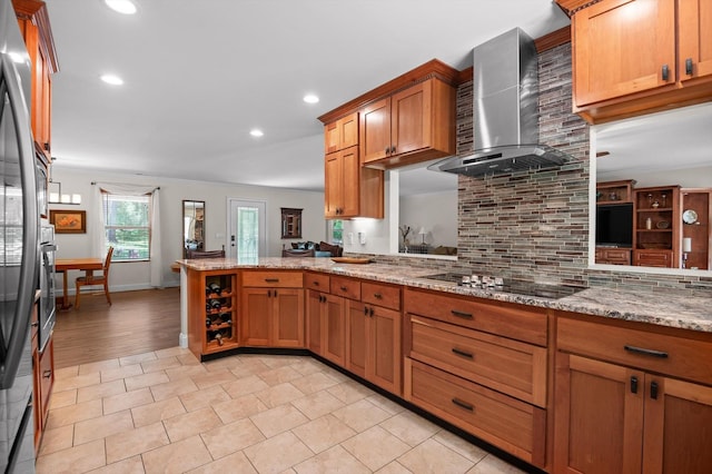 204 Chapman Ct, La Fayette, GA 30728 - kitchen featuring black electric stovetop, wall chimney range hood, tasteful backsplash, brown cabinetry, and a peninsula