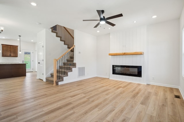 1441 Isaiah Dr, Clarksville, TN 37042 - unfurnished living room with light wood-type flooring, stairway, a ceiling fan, a fireplace, and recessed lighting