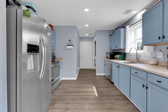 681 Crescent Rd, Murfreesboro, TN 37128 - kitchen with appliances with stainless steel finishes, a sink, blue cabinetry, light countertops, and light wood-style flooring