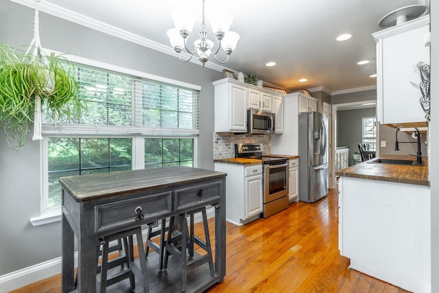 177 Oak Meadow Dr, Rock Spring, GA 30739 - kitchen with stainless steel appliances, a sink, crown molding, dark countertops, and white cabinets
