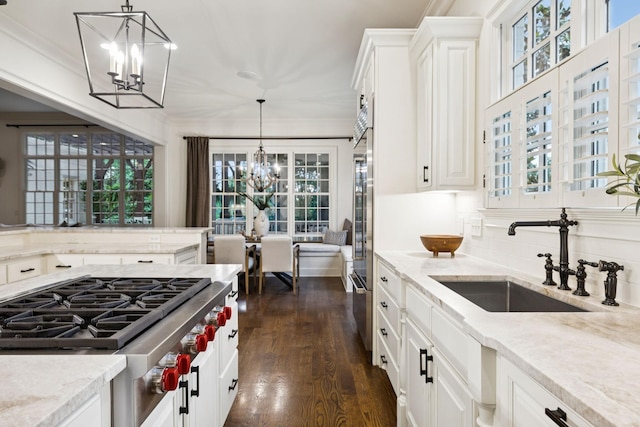 1616 Championship Blvd, Franklin, TN 37064 - kitchen featuring stainless steel gas cooktop, a sink, a chandelier, dark wood-style flooring, and light stone countertops