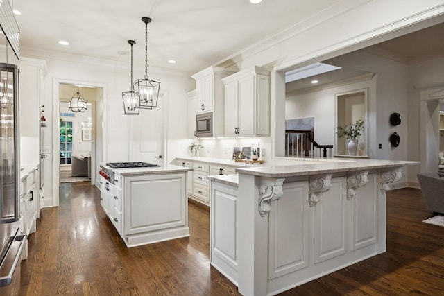 1616 Championship Blvd, Franklin, TN 37064 - kitchen featuring stainless steel microwave, ornamental molding, a kitchen bar, white cabinets, and backsplash