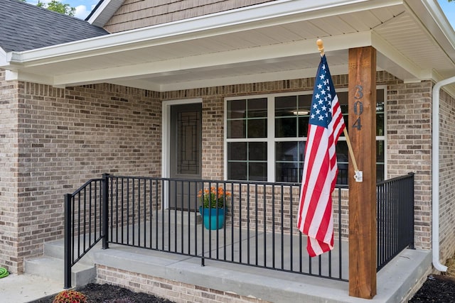 304 S Maple St, Hohenwald, TN 38462 - property entrance featuring brick siding, a porch, and a shingled roof
