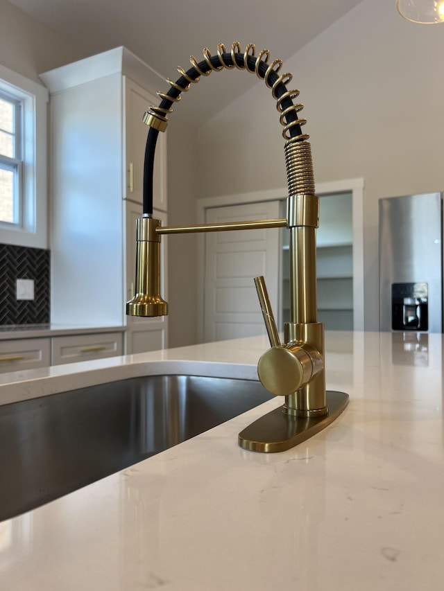 281 Bluebell Dr, Clarksville, TN 37043 - kitchen view of decorative backsplash, white cabinetry, and a sink