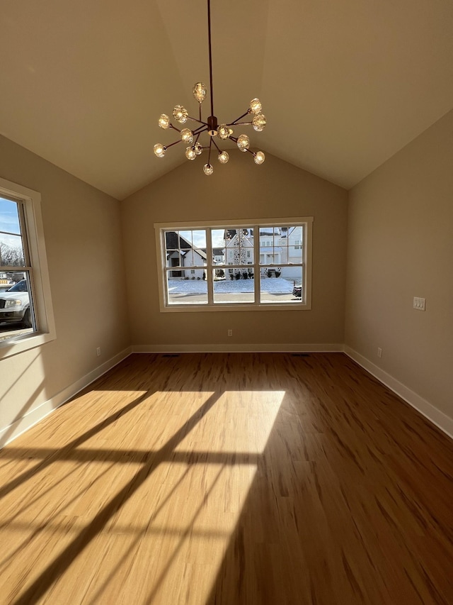 281 Bluebell Dr, Clarksville, TN 37043 - unfurnished dining area with a chandelier, plenty of natural light, vaulted ceiling, wood finished floors, and baseboards