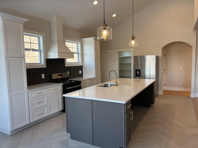 281 Bluebell Dr, Clarksville, TN 37043 - kitchen with a sink, premium range hood, arched walkways, black range with gas stovetop, and light countertops