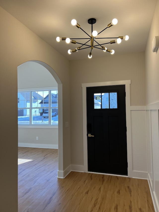 281 Bluebell Dr, Clarksville, TN 37043 - entryway featuring arched walkways, light wood-style floors, a chandelier, and baseboards