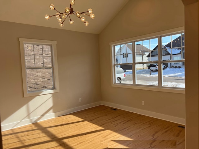 281 Bluebell Dr, Clarksville, TN 37043 - unfurnished room with plenty of natural light, a chandelier, wood finished floors, baseboards, and vaulted ceiling