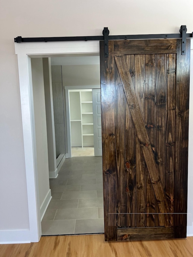 281 Bluebell Dr, Clarksville, TN 37043 - hall featuring a barn door, baseboards, and wood finished floors