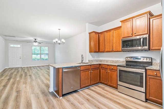 913 Battleview Pl, Murfreesboro, TN 37128 - kitchen with appliances with stainless steel finishes, a sink, brown cabinets, and light wood-style flooring