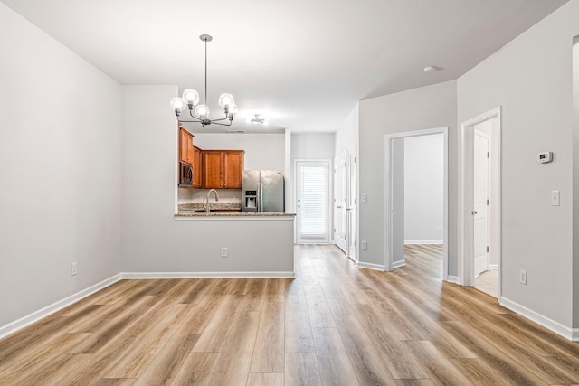 913 Battleview Pl, Murfreesboro, TN 37128 - kitchen with appliances with stainless steel finishes, brown cabinetry, a chandelier, light wood-style flooring, and hanging light fixtures