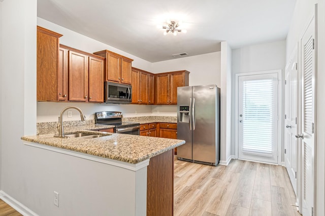 913 Battleview Pl, Murfreesboro, TN 37128 - kitchen with appliances with stainless steel finishes, a sink, brown cabinets, light stone counters, and a peninsula