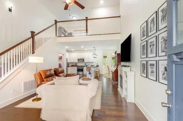 201 Hart Ln, Lebanon, TN 37087 - living area with a ceiling fan, dark wood-style flooring, stairs, a fireplace, and a towering ceiling