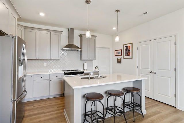 425 Multrees Pl, Smyrna, TN 37167 - kitchen featuring appliances with stainless steel finishes, wall chimney range hood, a sink, light wood-style floors, and gray cabinets