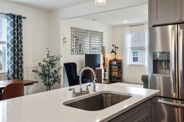 425 Multrees Pl, Smyrna, TN 37167 - kitchen featuring stainless steel refrigerator with ice dispenser, a sink, gray cabinets, light stone counters, and healthy amount of natural light