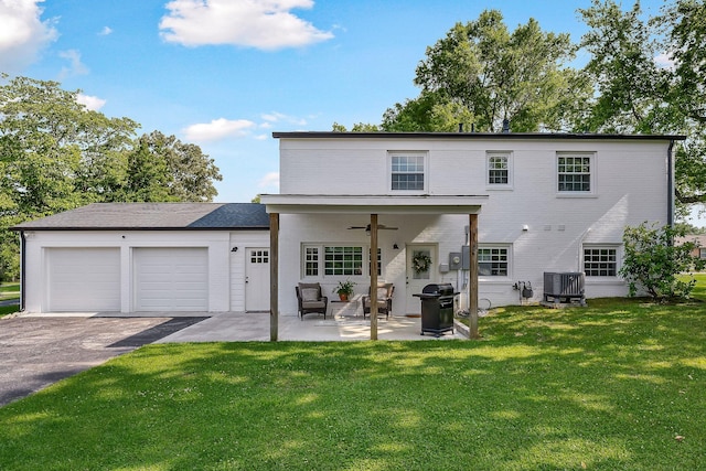 1508 Barnes Dr, Cookeville, TN 38501 - rear view of house featuring asphalt driveway, a garage, a yard, and a ceiling fan