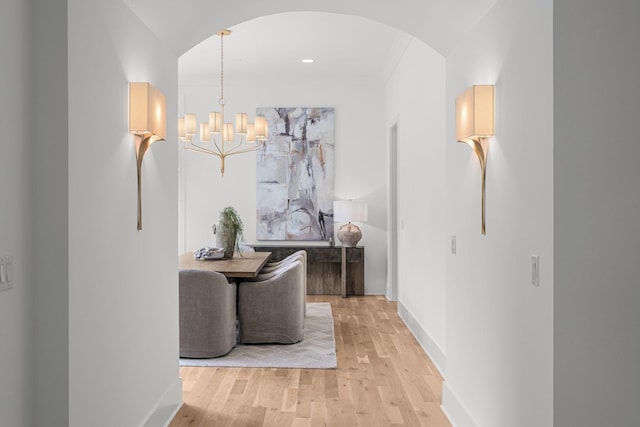 609 Bowling Ave, Nashville, TN 37215 - hallway with arched walkways, light wood-style flooring, baseboards, and a chandelier
