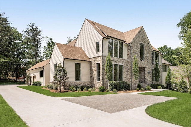 609 Bowling Ave, Nashville, TN 37215 - view of front of property featuring stone siding, concrete driveway, a front yard, and a shingled roof