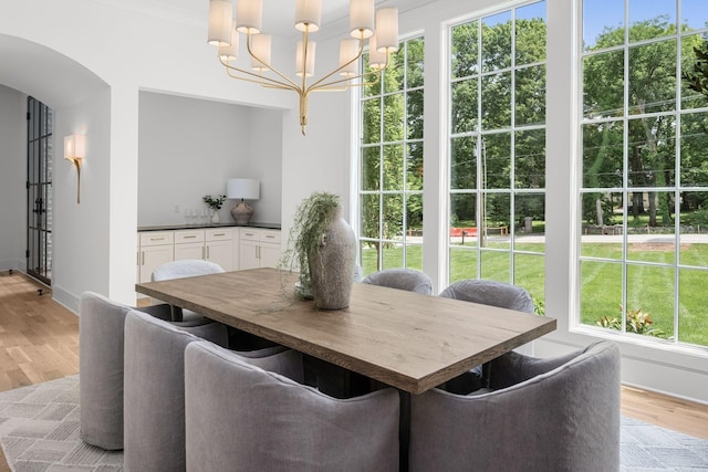 609 Bowling Ave, Nashville, TN 37215 - dining room with a chandelier, arched walkways, light wood finished floors, and baseboards