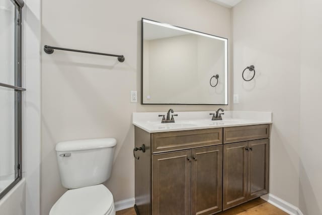 1445 Isaiah Dr, Clarksville, TN 37042 - full bathroom featuring double vanity, baseboards, toilet, and wood finished floors