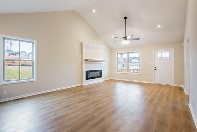 1445 Isaiah Dr, Clarksville, TN 37042 - unfurnished living room featuring ceiling fan, a glass covered fireplace, light wood-style floors, high vaulted ceiling, and baseboards