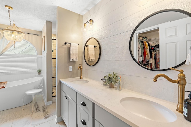 503 Hollyhock Way, Franklin, TN 37064 - bathroom featuring double vanity, a soaking tub, a chandelier, a walk in closet, and a textured ceiling
