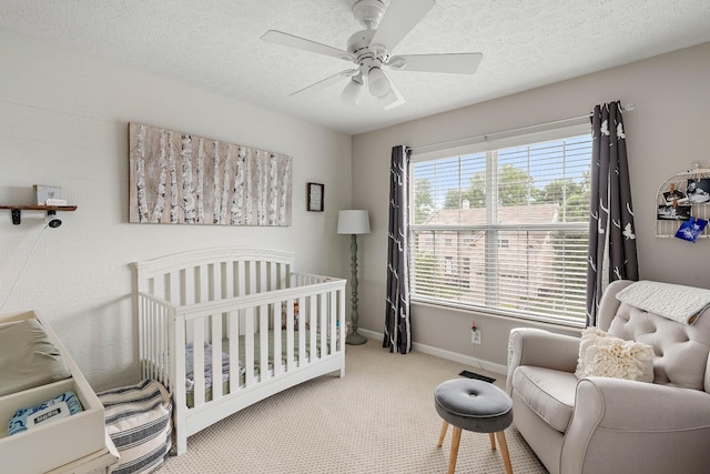503 Hollyhock Way, Franklin, TN 37064 - bedroom with baseboards, a crib, carpet flooring, a textured ceiling, and a ceiling fan