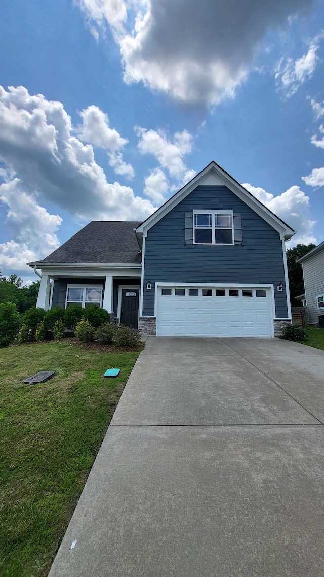 1060 Brayden Dr, Fairview, TN 37062 - view of front of home with an attached garage, concrete driveway, a front lawn, and stone siding