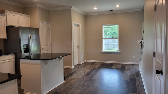 1060 Brayden Dr, Fairview, TN 37062 - kitchen with dark wood-style flooring, white cabinets, dark countertops, baseboards, and crown molding