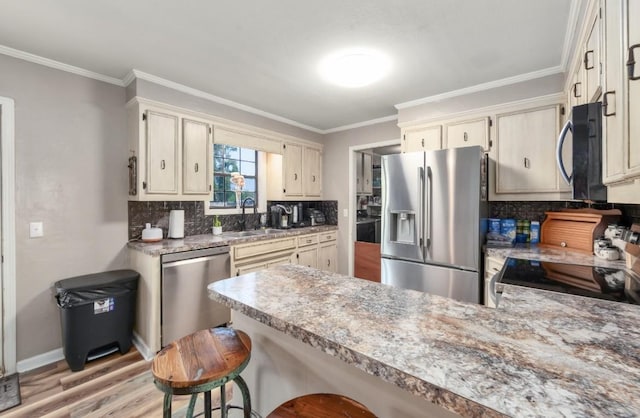 235 Pinecrest Dr, Henderson, TN 38340 - kitchen with appliances with stainless steel finishes, a sink, a peninsula, backsplash, and light wood-style floors