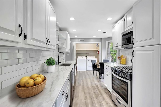 1284 Heritage Landing Dr, Chattanooga, TN 37405 - kitchen with a sink, appliances with stainless steel finishes, washer and clothes dryer, white cabinetry, and recessed lighting
