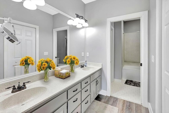 1284 Heritage Landing Dr, Chattanooga, TN 37405 - full bathroom with double vanity, toilet, wood finished floors, shower / bathtub combination, and baseboards