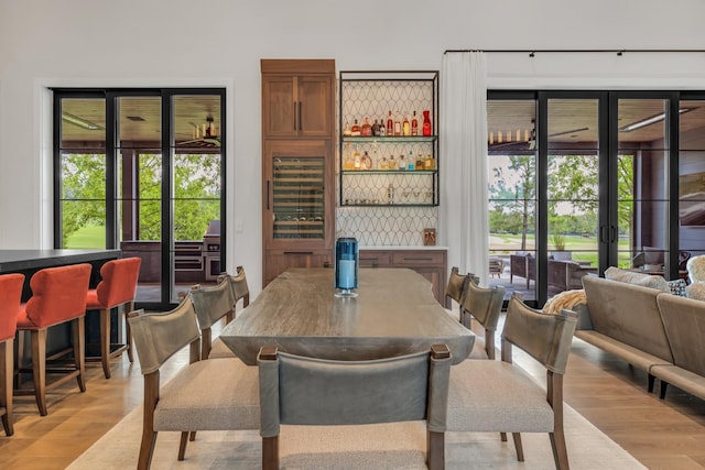 7313 Harlow Dr, College Grove, TN 37046 - dining area featuring a bar, light wood-type flooring, healthy amount of natural light, and french doors