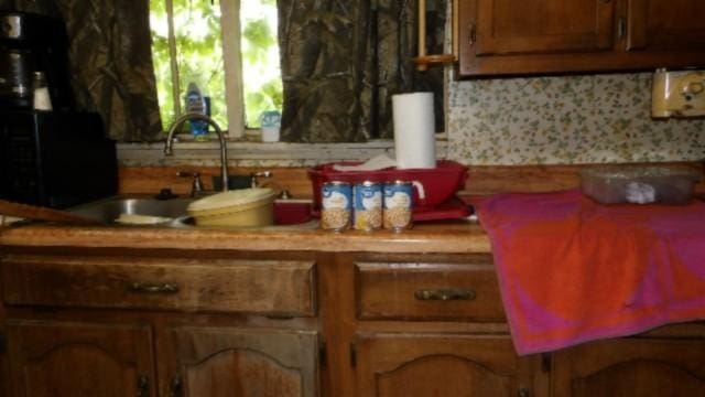 105 Log Home Ln, Moss, TN 38575 - kitchen with light countertops, brown cabinetry, and a sink