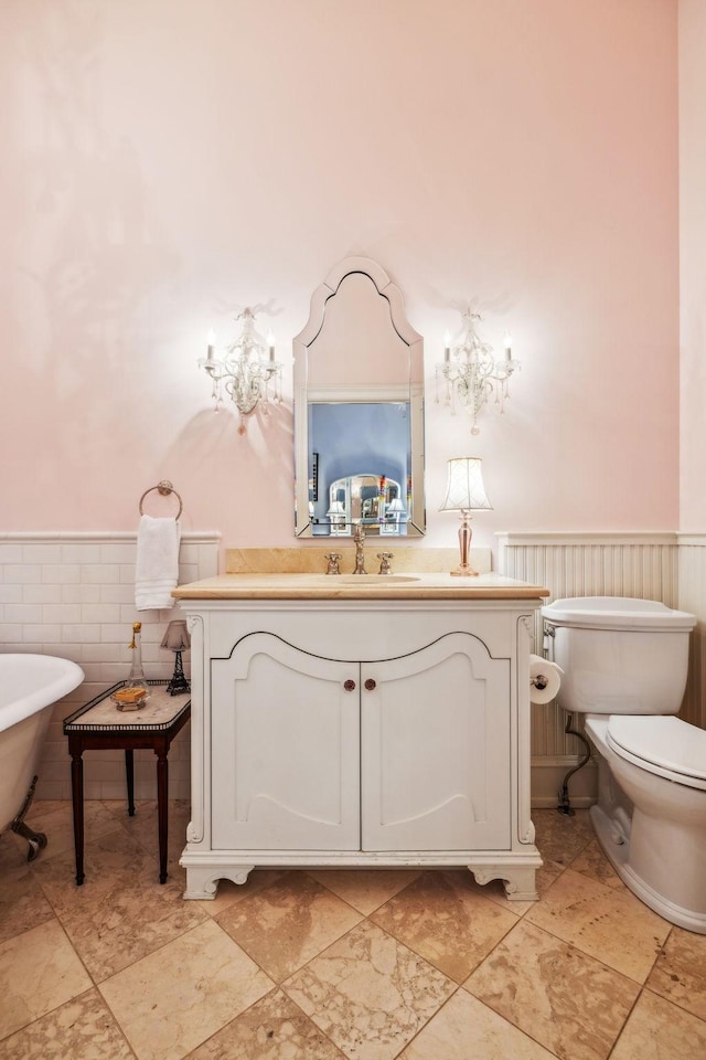 224 3rd Ave S, Franklin, TN 37064 - bathroom featuring wainscoting, a chandelier, toilet, vanity, and a freestanding tub
